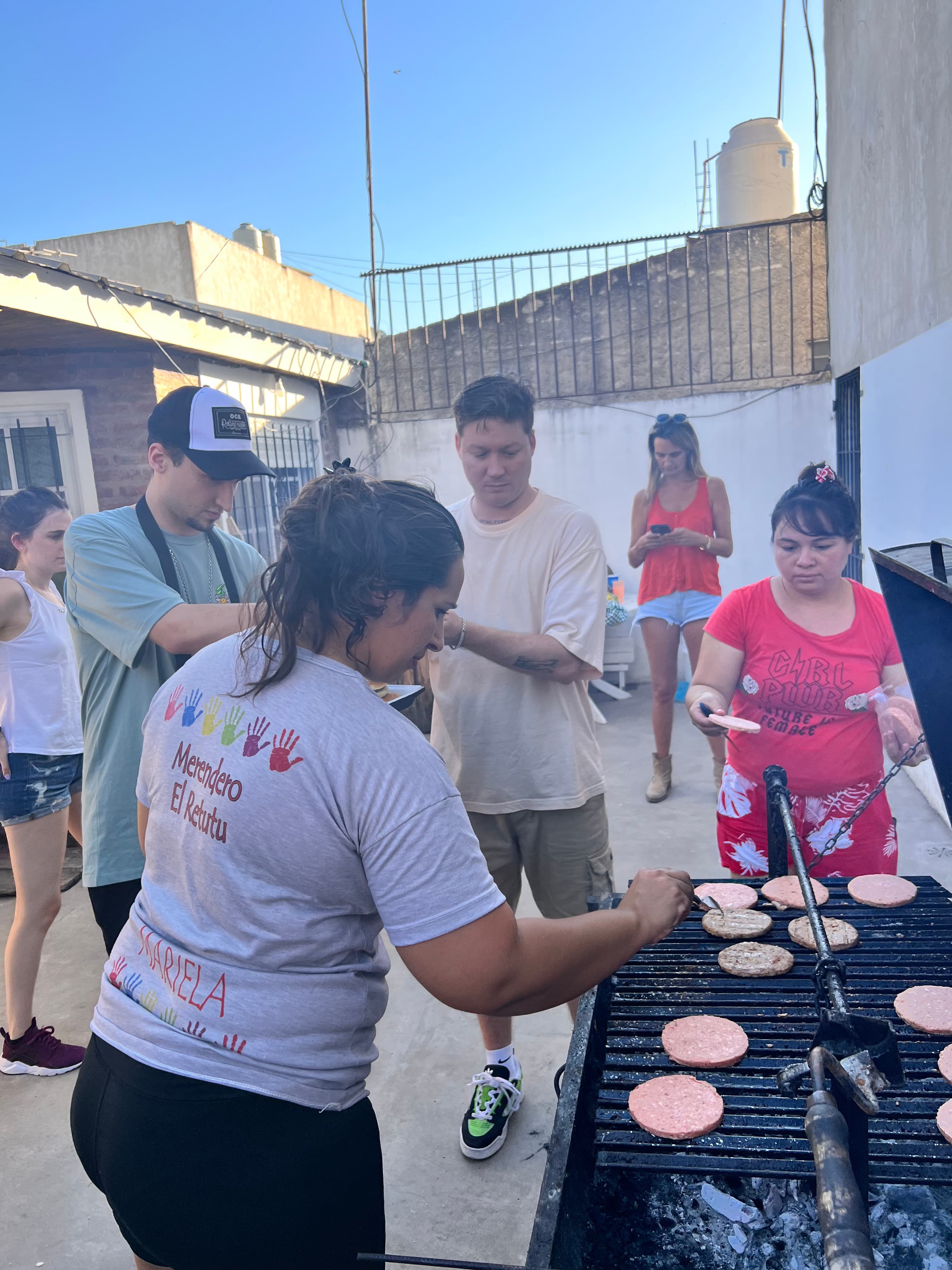 Voluntarios cocinando un asado para el merendero